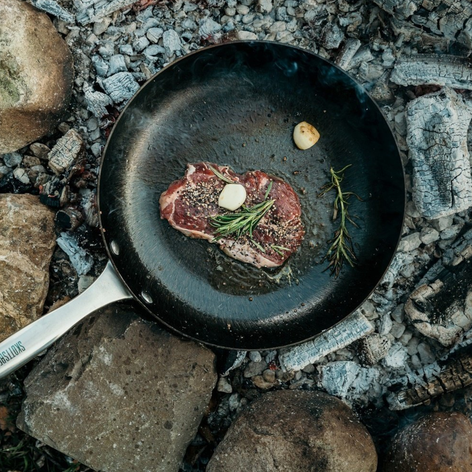 Pfanne auf einem Grill mit Fleisch und Gemüse